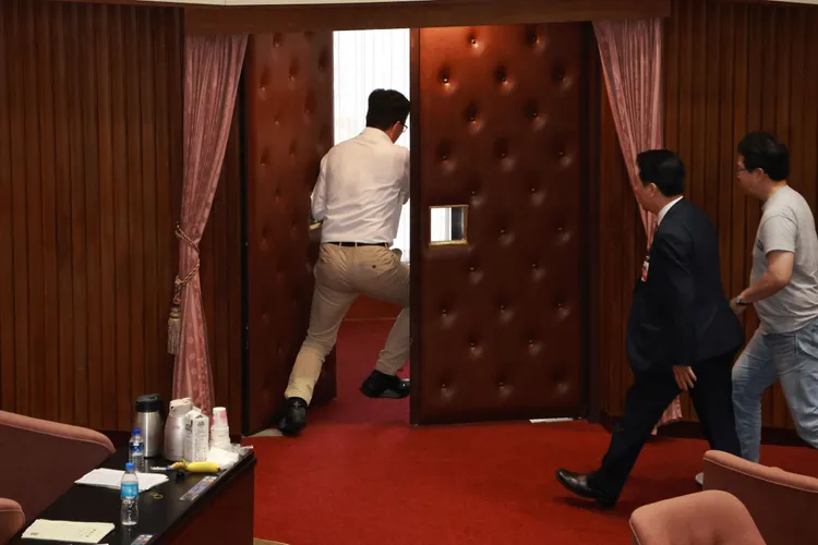 郭國文搶到議事本直衝出議事場外。彭欣偉攝