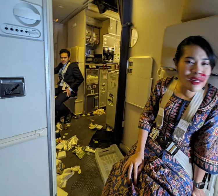 新航SQ321客機遇上強烈亂流，飛機內一片狼籍，空服員（右）臉上受傷流血。翻攝　@BanditOnYour6的X