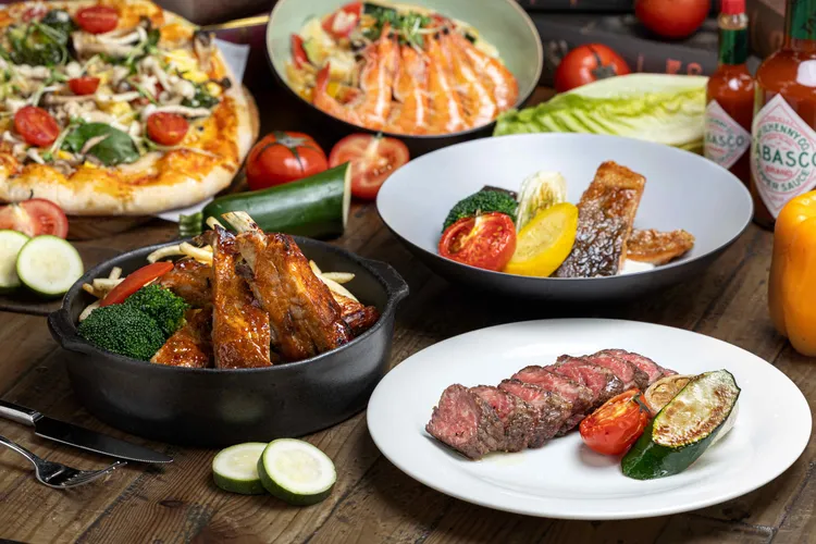 義饗食堂推出義式窯烤四人分享海陸大餐，豐盛餐點Prime無骨牛小排、BBQ豬肋排、檸檸檬奶油鮭魚排等精彩主菜。業者提供