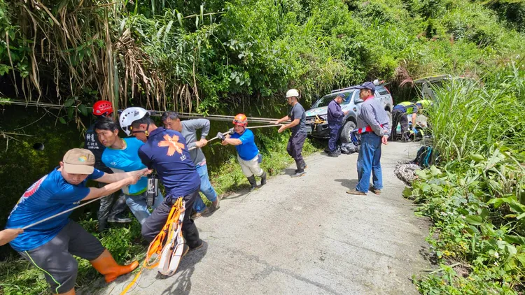 眾人合力拖起小貨車。南投縣消防局提供