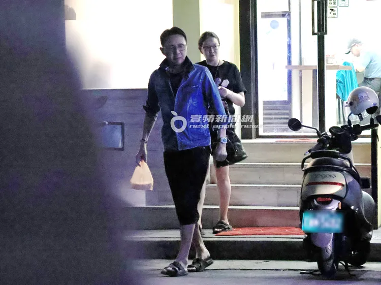 林立洋手提打包食物離開餐廳過馬路，老婆緊跟在後。特勤中心攝