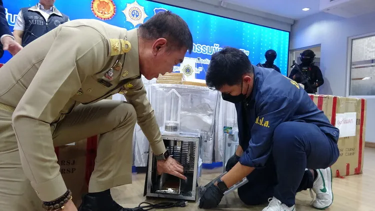 泰國警方14日攔截一批夾藏在飲料機內要運往台灣的海洛因，肅毒委員會15日舉行記者會說明案情，肅毒委員會祕書長帕努拉（左）指出海洛因夾藏的位置。中央社