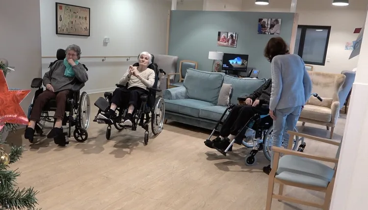 走進法國首座阿茲海默村，記者在訪問工作人員時，一位老先生總無意識地大叫。村民莫瑞爾（灰衣背對者）擔心收音，不斷起身安撫對方。她告訴中央社，村莊是「天上最美的東西，美好的事物都在身邊，讓人幸福」。中央社