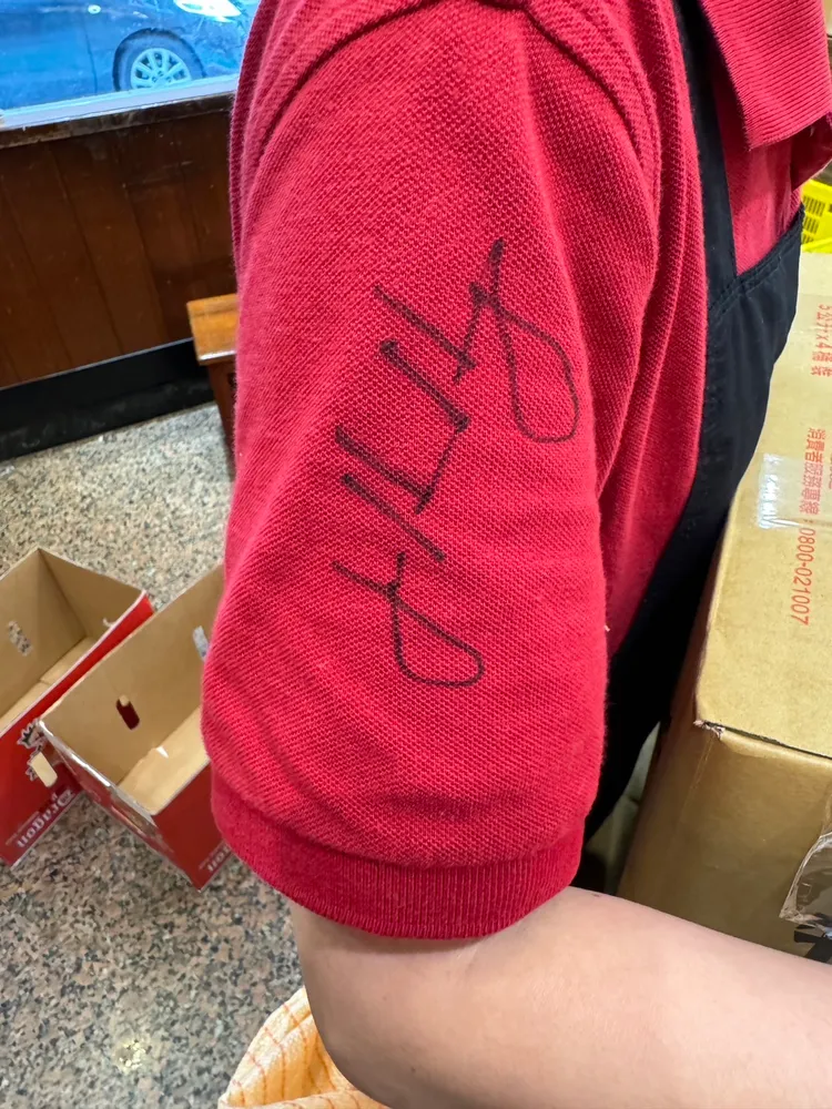 黃仁勳親民的在店員的衣服上簽名。特勤中心攝