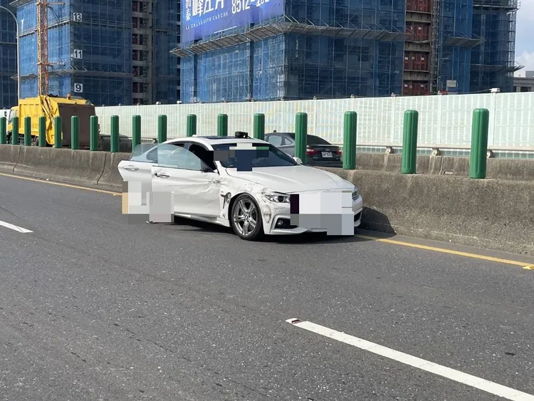 白色BMW不知何故與同向的小貨車發生擦撞，造成小貨車翻覆，駕駛也命危送醫。讀者提供