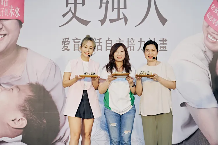 季芹（左一）今天在公益活動上，與2位視障媽媽比賽做家事。愛盲基金會提供