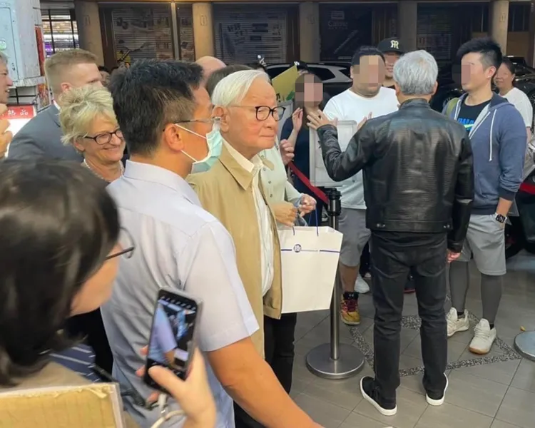 「AI教父」黃仁勳（右）跟民眾搏感情，外國保鑣在旁維安，張忠謀也帶著貼身保鑣隨行。讀者提供