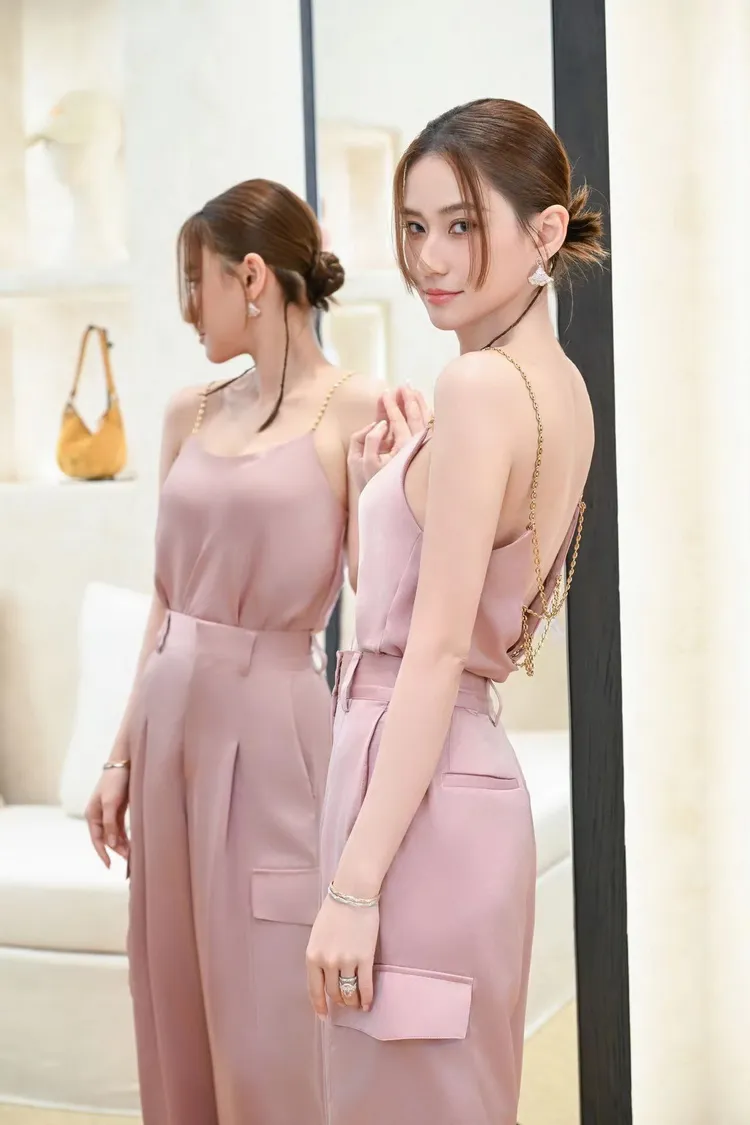 背心後方僅以金色細鍊條輕輕連接起兩側布料。品牌提供