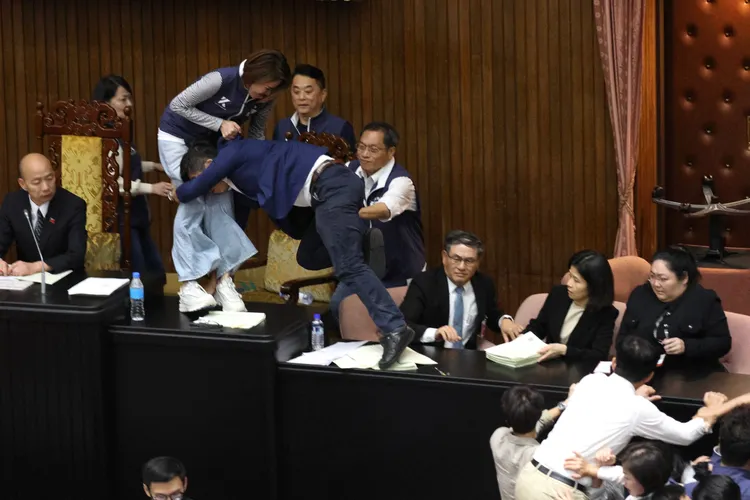 陳菁徽遭鍾佳濱飛撲，兩人雙雙摔至韓國瑜一旁的預備席。彭欣偉攝