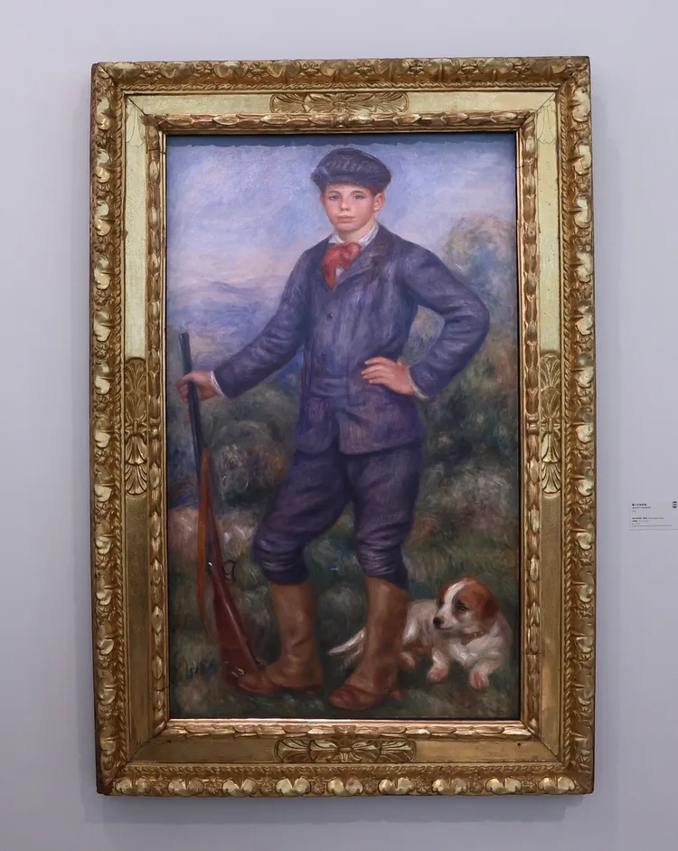 雷諾瓦1910年完成這幅描繪他15歲兒子尚，穿著打獵服站在家中狗旁邊的畫作《獵人尚雷諾》。彭欣偉攝
