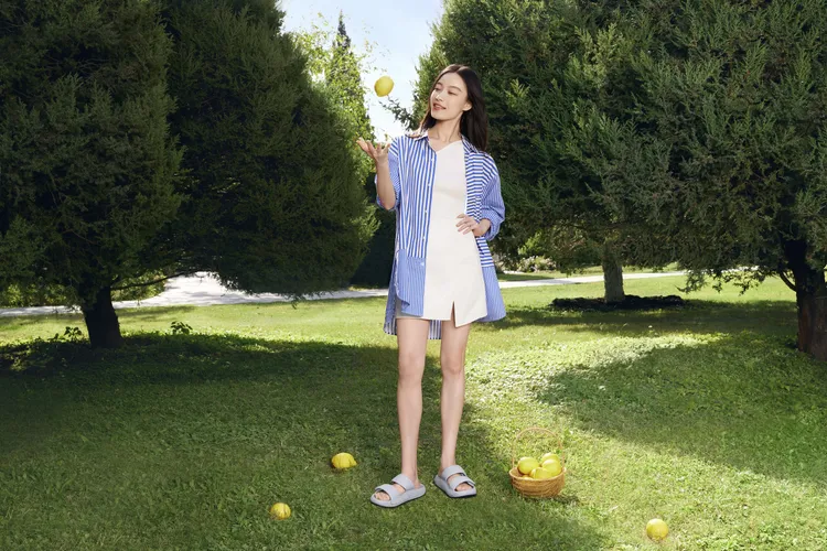 倪妮穿著條紋襯衫、鞋尖螺紋背心杏色開衩短裙，造型相當愜意。品牌提供