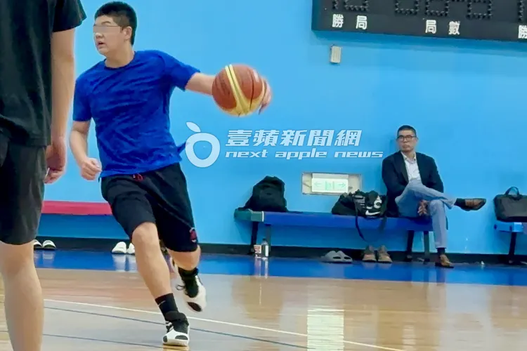 連勝文（右）坐在板凳區專注陪伴兒子打籃球。特勤中心攝