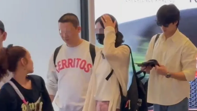 安普賢（右）跟著一般民眾一起排隊等候出境，吸引不少粉絲列隊歡送，讓前方旅客（左）相當好奇頻頻回頭看安普賢。特勤中心攝