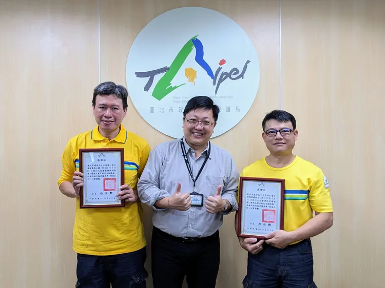 北市清潔隊員蔡佳宏與高士鎮在搬運大型廢棄物時，發現民眾的紅包。北市環保局提供