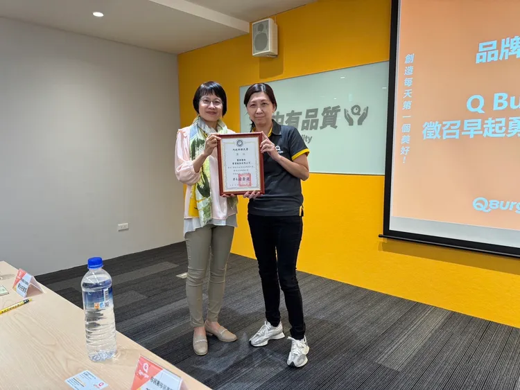 移民事務組黃組長齡玉頒發給Q Burger饗樂餐飲「新住民就業友善企業。移民署提供