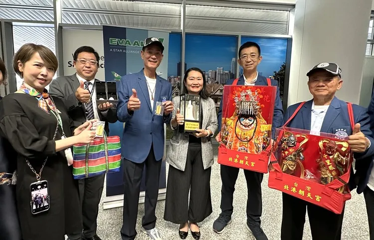 北港媽祖搭乘長榮班機平安抵美，朝天宮董事長蔡咏鍀（左三）特別準備白玉媽祖、符令餅乾，贈送給航空公司人員，感謝盡心幫忙，長榮航空美洲總分公司協理葉佳怡（右三）接受結緣品。中央社