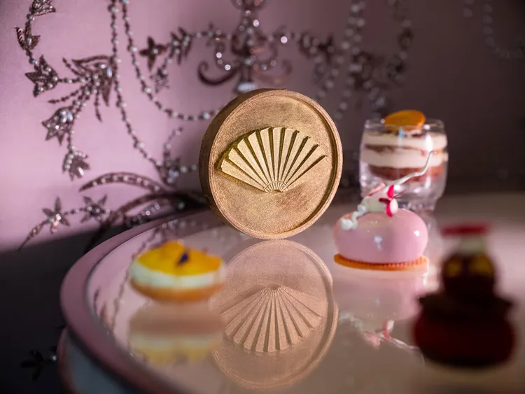 巧克力焦糖堅果瑪德蓮: 外層以58%黑巧克力製成，口感酥脆，中間夾入杏仁與榛果醬，底部則搭配焦糖瑪德蓮，外型製成酒店集團標誌性的摺扇，整體帶有醇厚的焦糖與黑巧克力香氣。業者提供