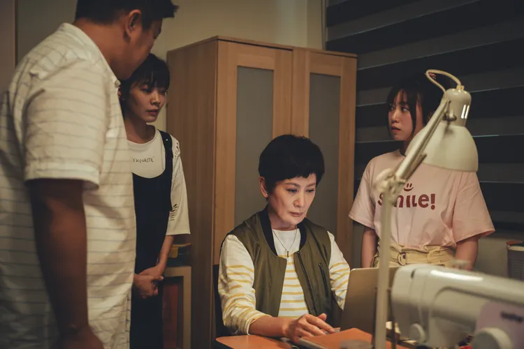 陳亞蘭（中）發現兒女們用電腦整理戲班從以前到現在的資料。公視台語台、華視提供