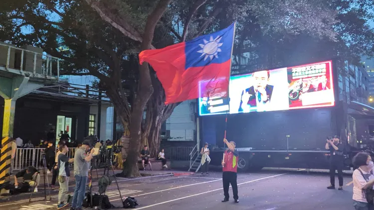 國民黨場僅看到韓粉「挑大師」廖盛芳一人高舉國旗。蘇柏銓攝