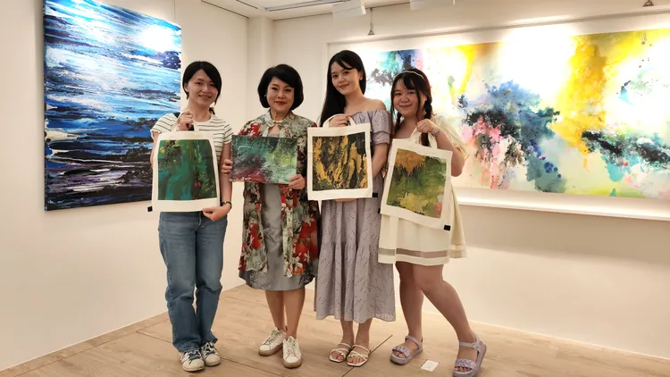 謝麗美女士與同學們合影，並贈送印有畫作的手提袋給同學。