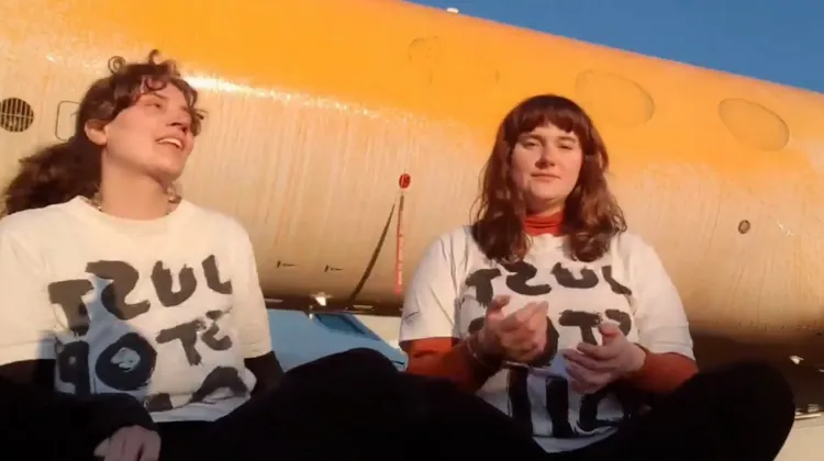 兩位女環保人士闖進機場禁區對私人飛機噴漆並錄製影片。翻攝Stop the Oil