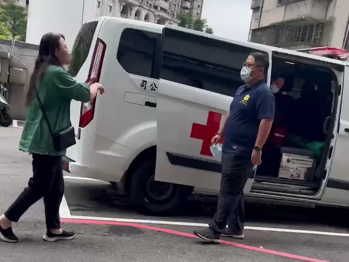 民眾投訴莊員（右）涉嫌違反公務員不得兼職規定，穿著該民間救護車公司工作服，載送病患。民眾提供