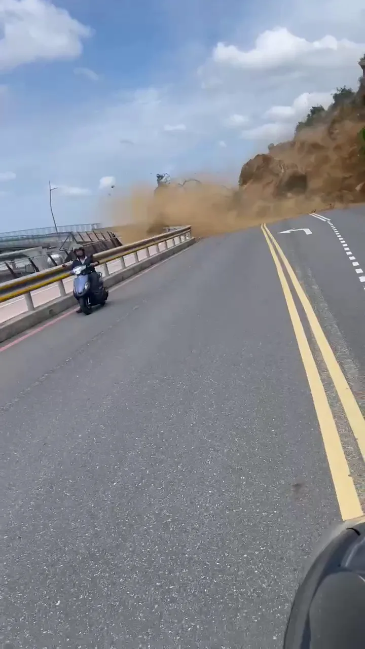 騎士見前方山壁崩落，嚇得猛催油門逃命。翻攝畫面