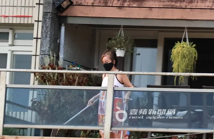 狄鶯身穿細肩帶花裙，在家中露天陽台打掃。特勤中心攝