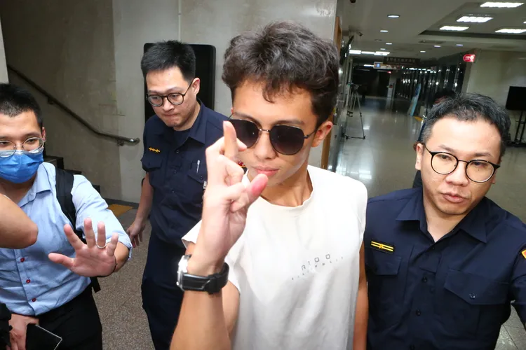 孫安佐19日深夜交保後離開北檢，模仿五條悟的無量空處領域展開手勢。陳建岐攝