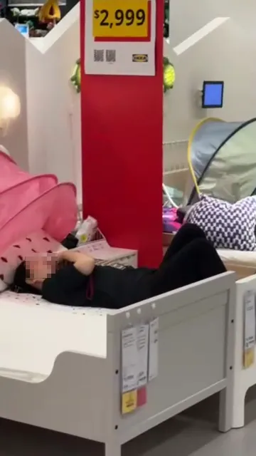 民眾拍下黑衣大媽上周五到IKEA新北店赤腳蹭床還大聊電話。讀者提供