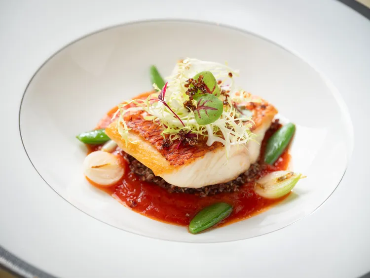 文華Café「平日午間饗．吃．吧」推出全新季節主餐：「嫩煎澎湖野生長尾濱鯛」吃起來無腥味，肉質緊實有彈性，搭配甜椒奶油醬和超級食物藜麥，不僅增加了口感上的多樣性，還帶來了細膩的顆粒感和堅果風味。業者提供