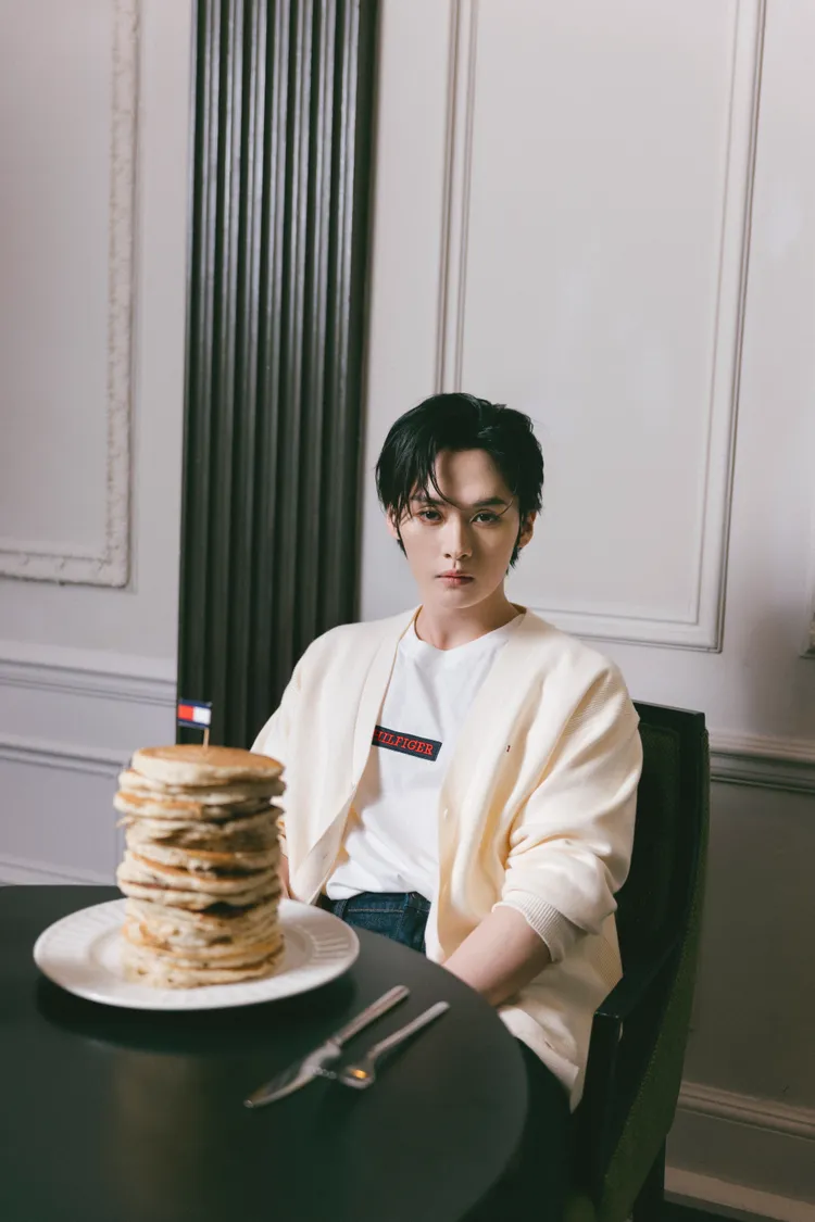 Lee Know穿著米色針織罩衫。品牌提供