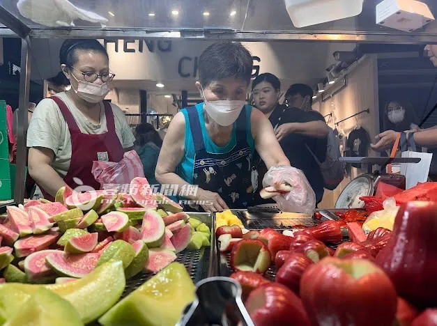 阿婆忙著處理水果給排隊客人。特勤中心攝