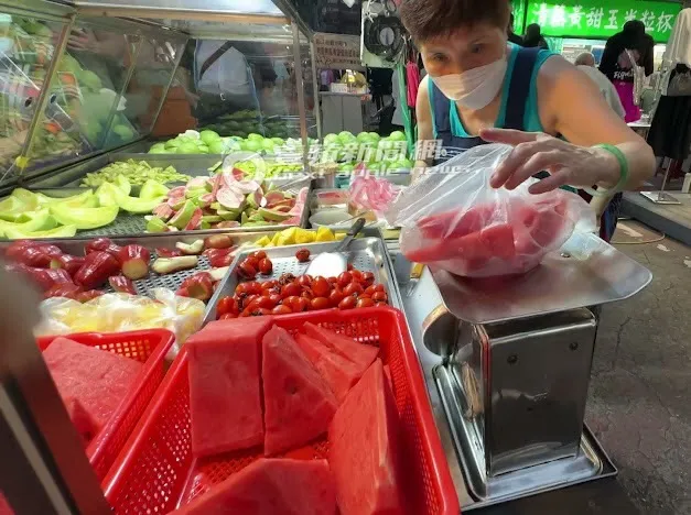 阿婆將西瓜放置秤上面，秤好以後準備切小。特勤中心攝