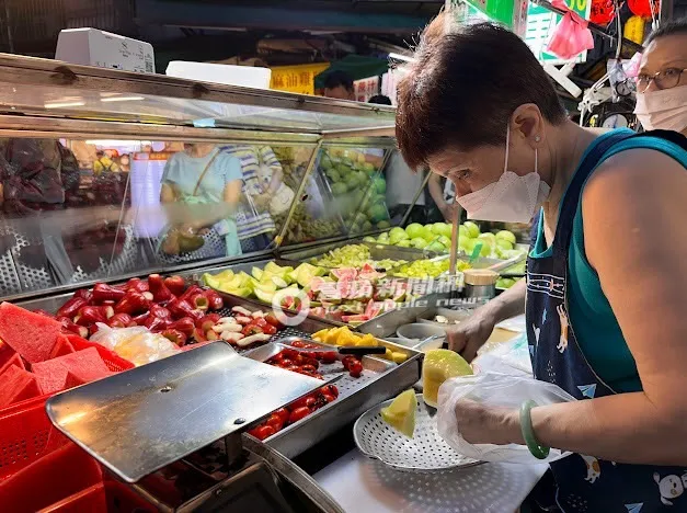 阿婆動作相當快速的將哈密瓜切小塊。特勤中心攝