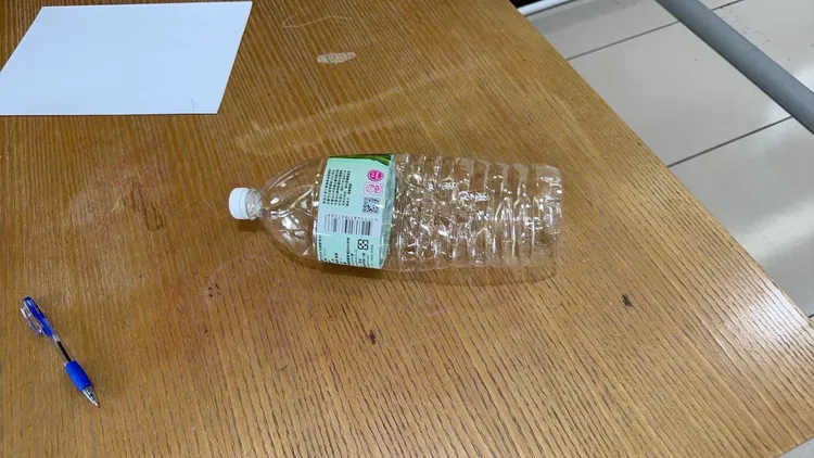 吳男從機車抽出汽油到寶特瓶，接著到營造公司潑汽油討債。翻攝畫面