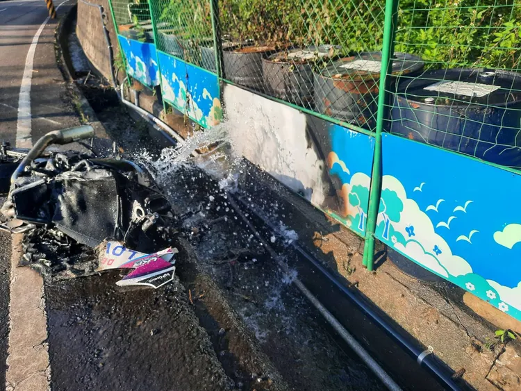 重機滑到對向撞斷水管後起火燃燒，被噴出的水柱撲滅。民眾提供