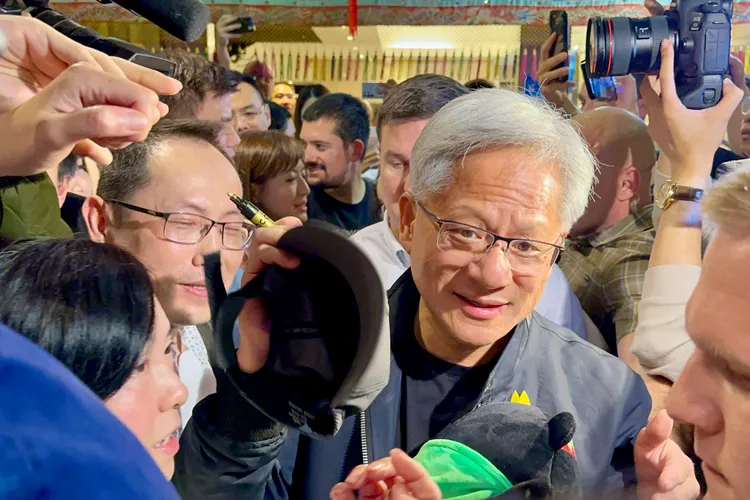 黃仁勳幫粉絲簽棒球帽。特勤中心攝