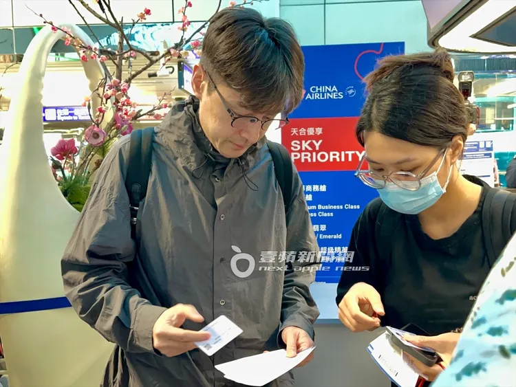 胡歌與一旁助理一同核對機票資料。特勤中心攝