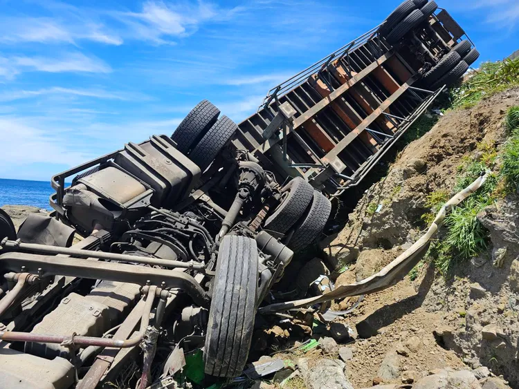 貨櫃車墜3公尺高邊坡後四輪朝天。消防局提供　