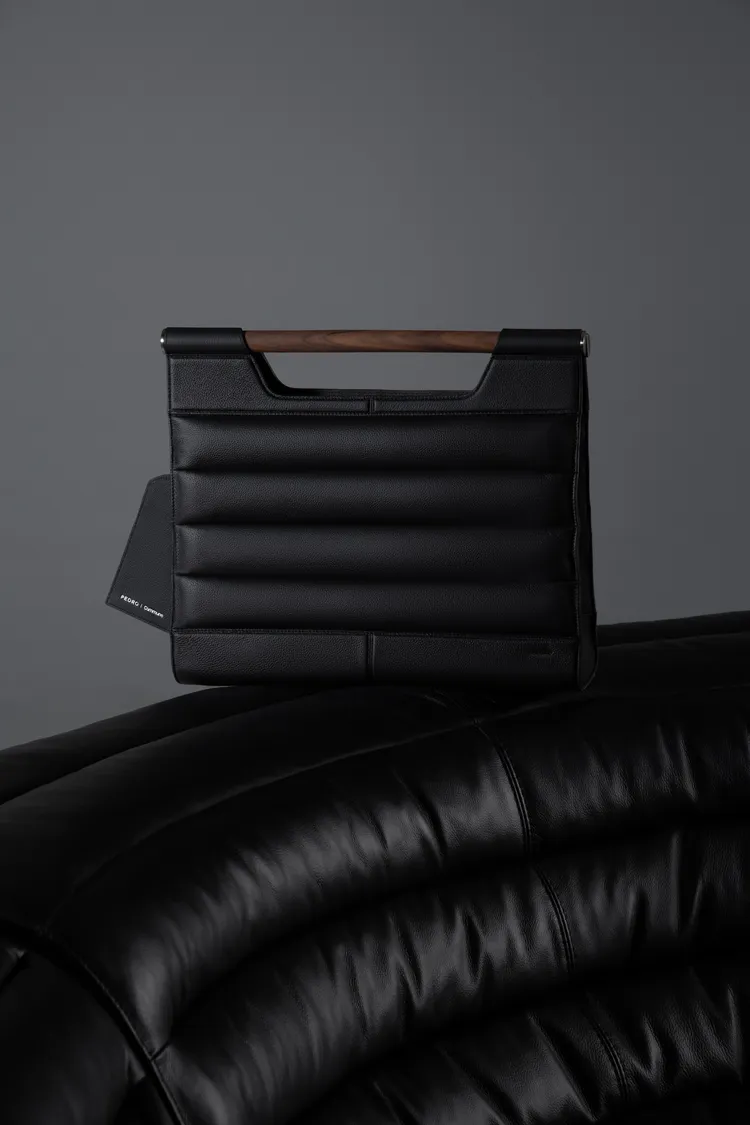 手提包提把採用沙發椅腳使用的天然胡桃木。品牌提供