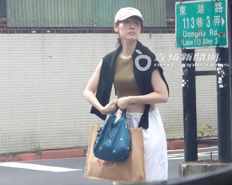 田中千繪享用完芒果雪花冰後，繼續扛著重物過馬路。特勤中心攝