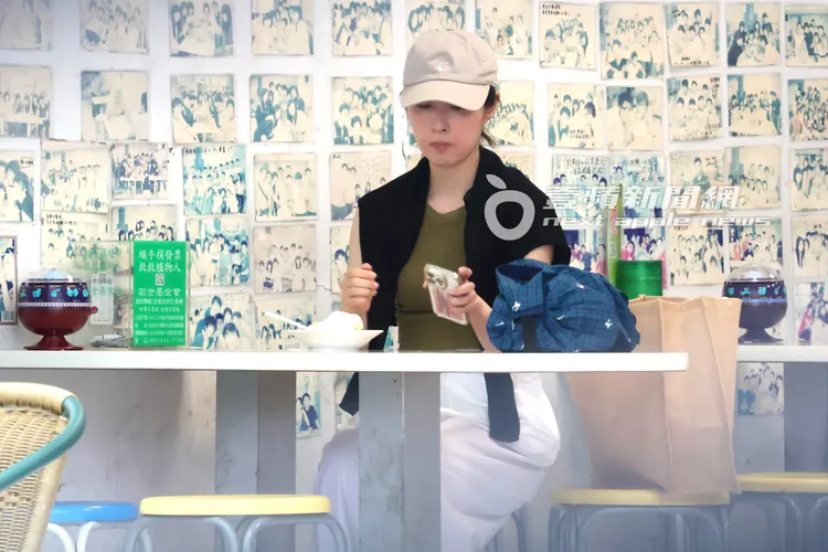 田中千繪邊吃冰邊滑手機。特勤中心攝