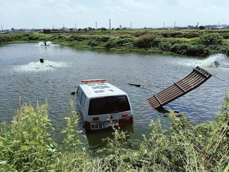 嘉義縣救護車因事故衝入魚塭，所幸車內2名隊員自行脫困。民眾提供