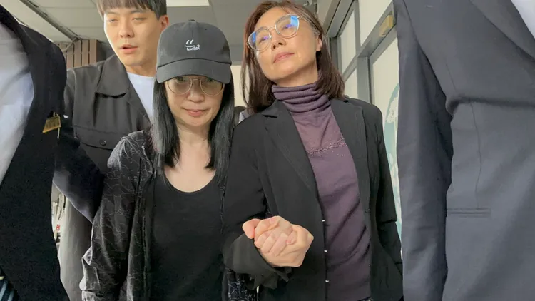 黃嘉千（左）素顏脫下口罩與律師賴芳玉離開。特勤中心攝