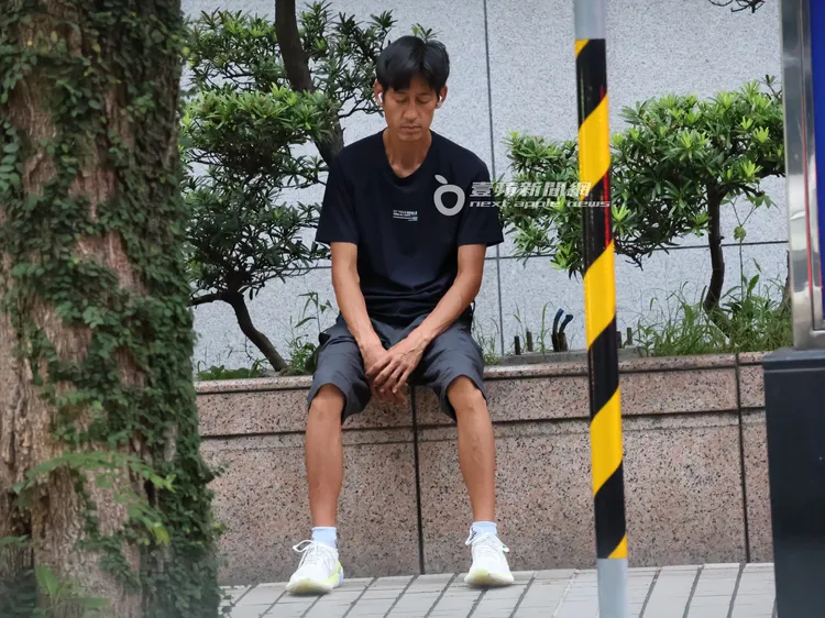 唐治平挺直腰桿閉著雙眼，靜靜地坐在花圃邊。特勤中心攝