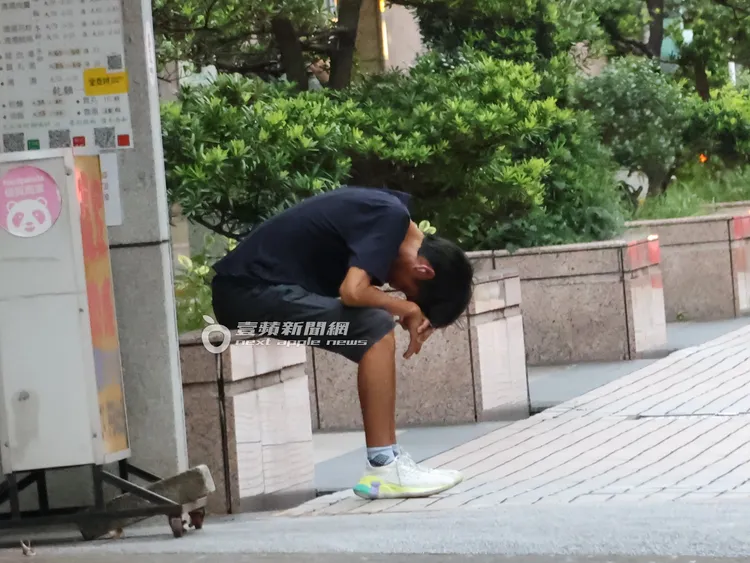 唐治平突然坐在路邊，彎著腰低著頭，走久了似乎有些疲憊。特勤中心攝