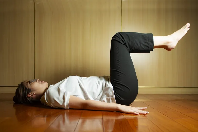 平躺屈膝：吸氣時雙腳併攏抬起成90度，腹部收緊，維持平緩呼吸10秒後慢慢回到原位。台北慈濟醫院提供