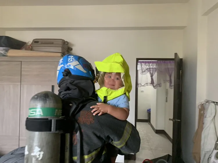 3歲男童戴上面罩，被消防員抱出火場時完全沒有哭鬧。雲林縣消防局提供