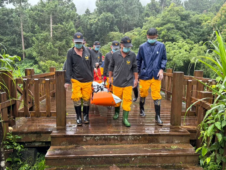 消防人員合力將老翁遺體搬運至步道。民眾提供
